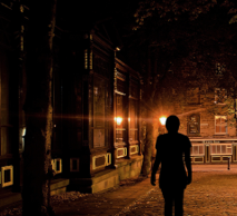 silhouette walking in the middle of a street at night